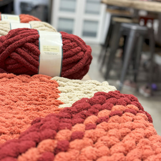 Close-up of red and beige yarn balls with a blurred indoor background