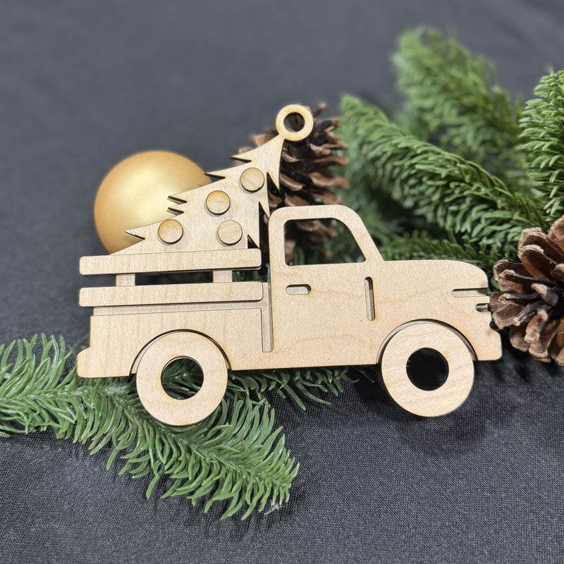 Wooden Christmas truck ornament with tree and ball on a dark background