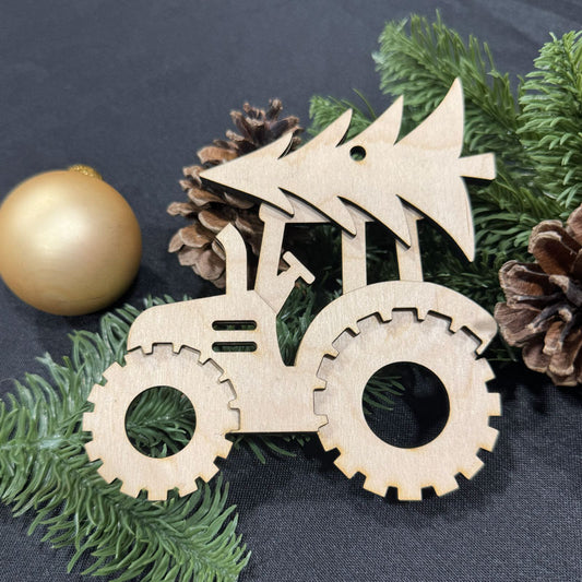 Wooden tractor ornament on a dark surface with greenery and pine cones.