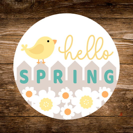 Circular sticker with a chick, flowers, and 'hello SPRING' text on a wooden background