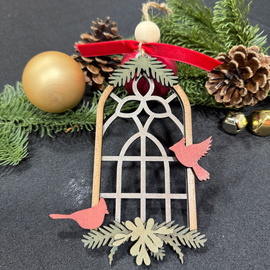 Decorative Christmas ornament with cardinals, snowflakes, and pinecones on a dark background