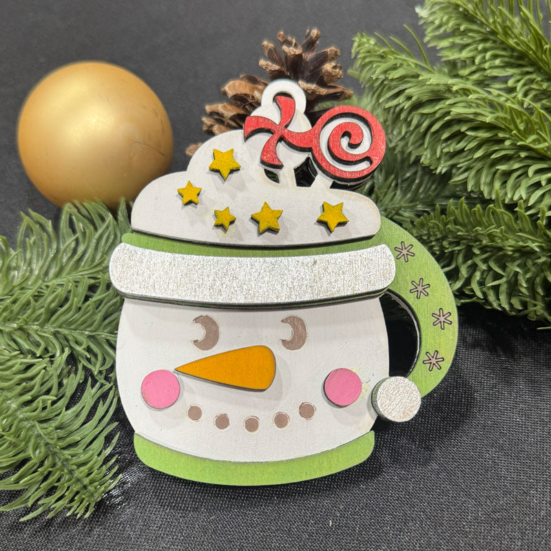 Decorative snowman mug with a candy cane hat on a dark background with greenery.