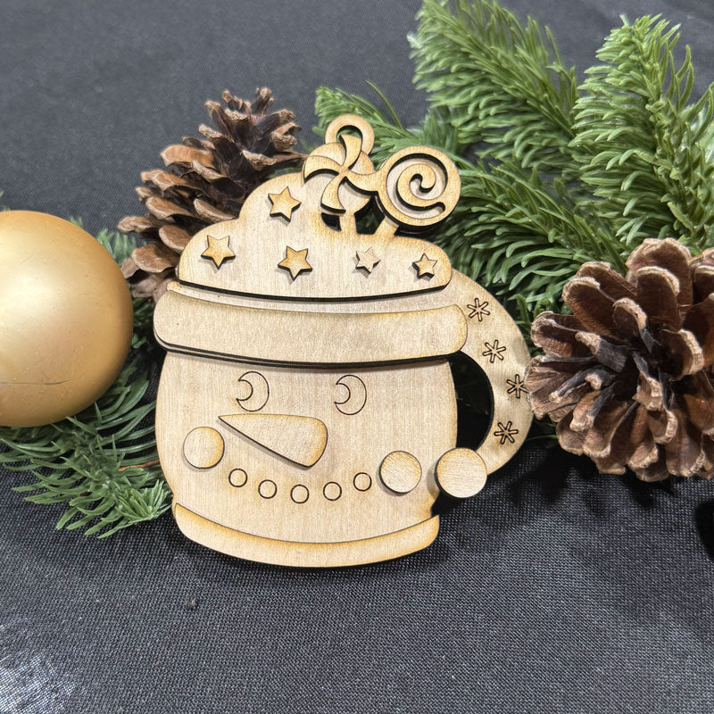 Wooden snowman ornament with decorative elements on a dark background with greenery and pine cones.