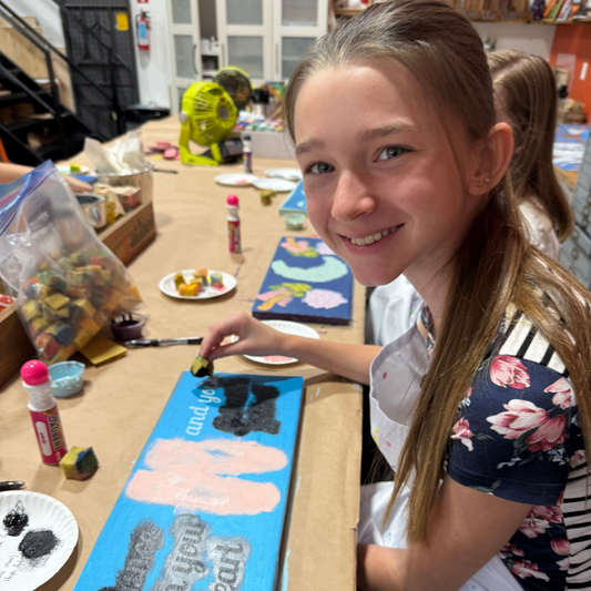 Girl working on a craft project at a table with various materials