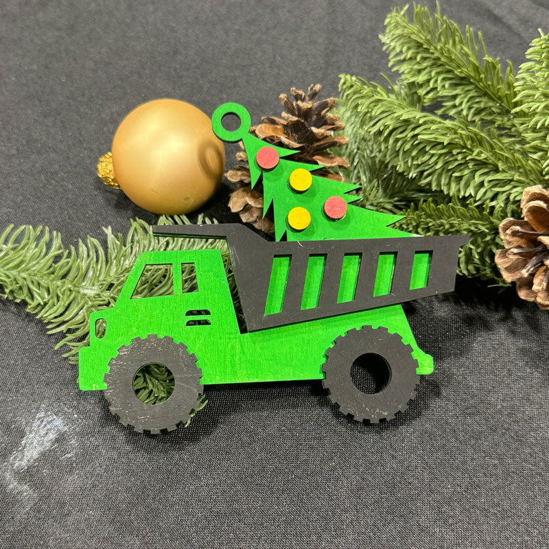 Green toy dump truck with Christmas decorations on a gray surface