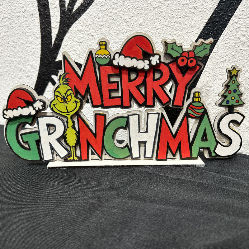 Decorative sign with 'Merry Grinchmas' text and Grinch character on a textured surface.
