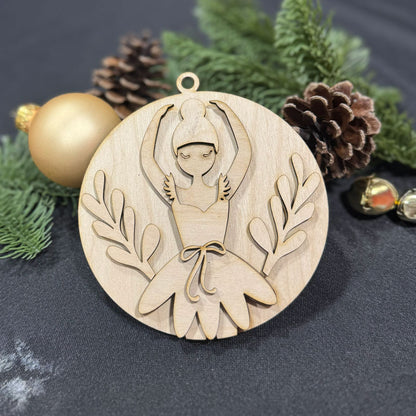 Wooden ornament with a design of a Ballerina, surrounded by Christmas decorations on a dark background.