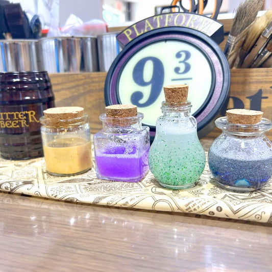 Assorted potion jars with cork lids on a table.