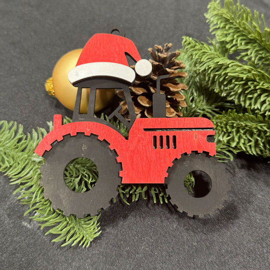 Red tractor ornament with a Santa hat on a gray background