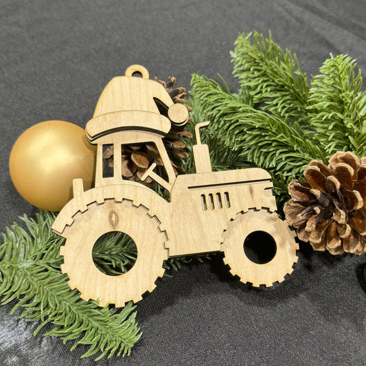 Wooden tractor ornament with pine branches and pinecones on a dark surface