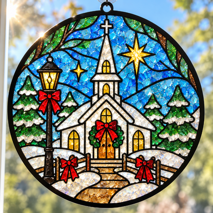 Round stained glass style suncatcher featuring a snowy winter church scene with a lit streetlamp, evergreen trees, red bows, and glowing stars against a blue sky.