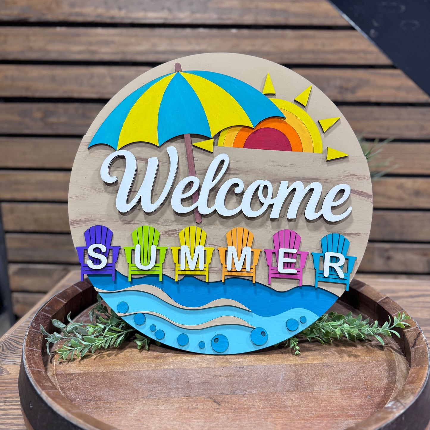 Decorative sign with 'Welcome Summer' text on a wooden surface