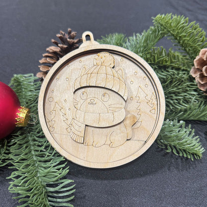 Wooden ornament with a cat design on a dark surface with greenery and a red ornament.